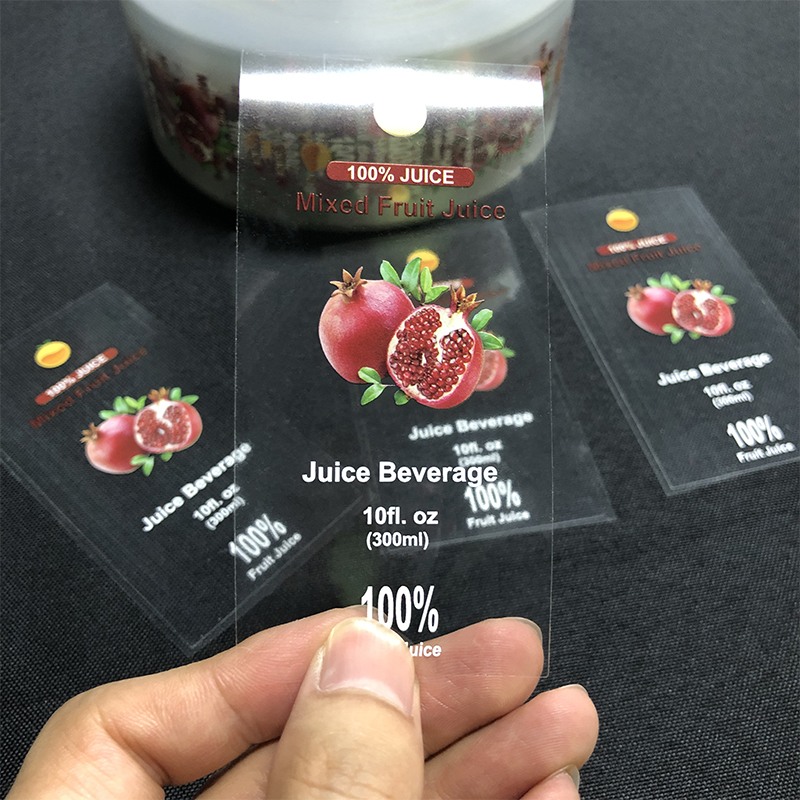 Clear pomegranate juice labels held by hand