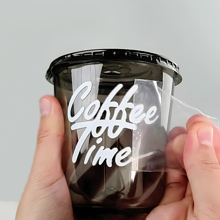 Clear coffee cup transfer decal being peeled